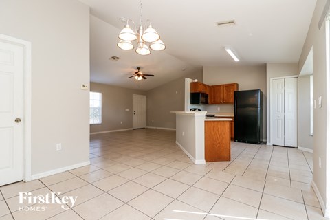 A kitchen with a white tile floor and a wooden island.