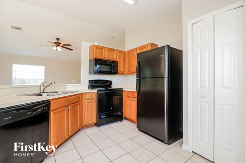 A kitchen with wooden cabinets and black appliances.