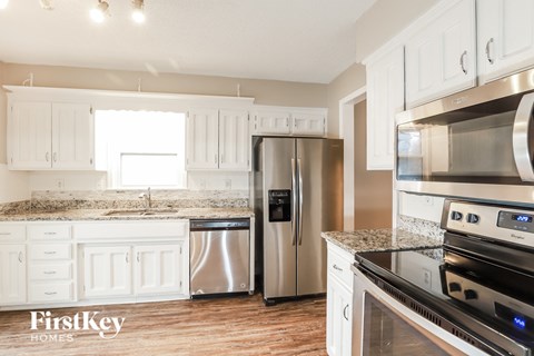 A kitchen with white cabinets and stainless steel appliances.
