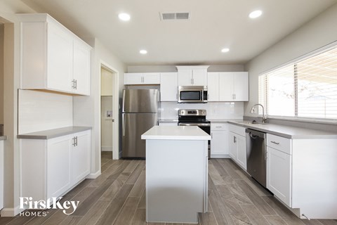 A modern kitchen with white cabinets and stainless steel appliances.
