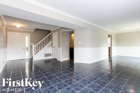 A spacious room with a staircase and a tiled floor.