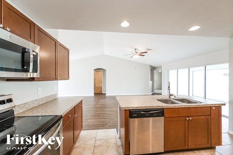 A kitchen with wooden cabinets and a stainless steel dishwasher.