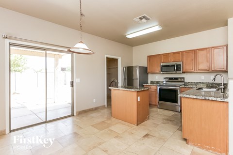 A kitchen with wooden cabinets and a tiled floor.