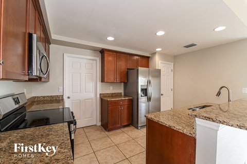 A kitchen with brown cabinets and a granite countertop.