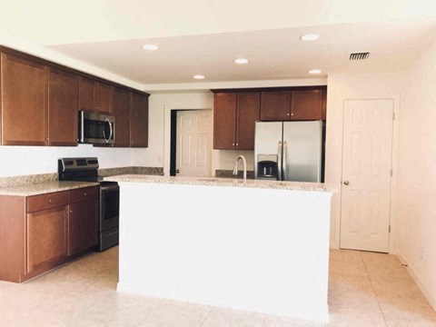 A kitchen with brown cabinets and a white island.