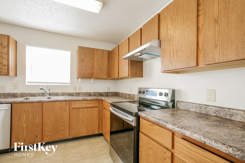 a kitchen with wooden cabinets and stainless steel appliances and granite counter tops