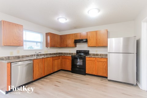 A kitchen with wooden cabinets and a stainless steel refrigerator.