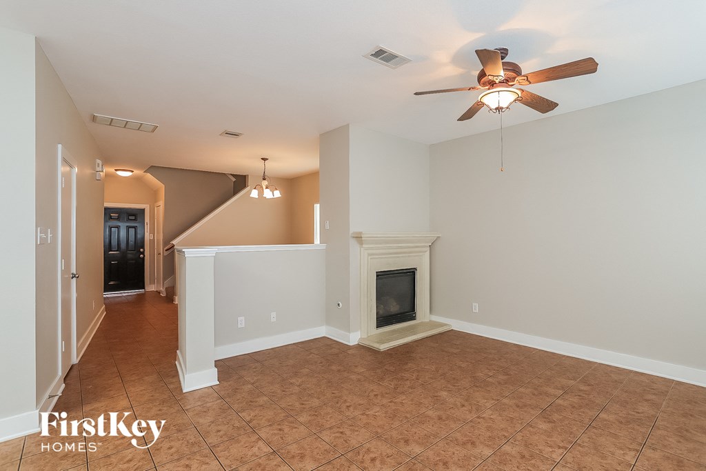 a living room with a fireplace and a ceiling fan