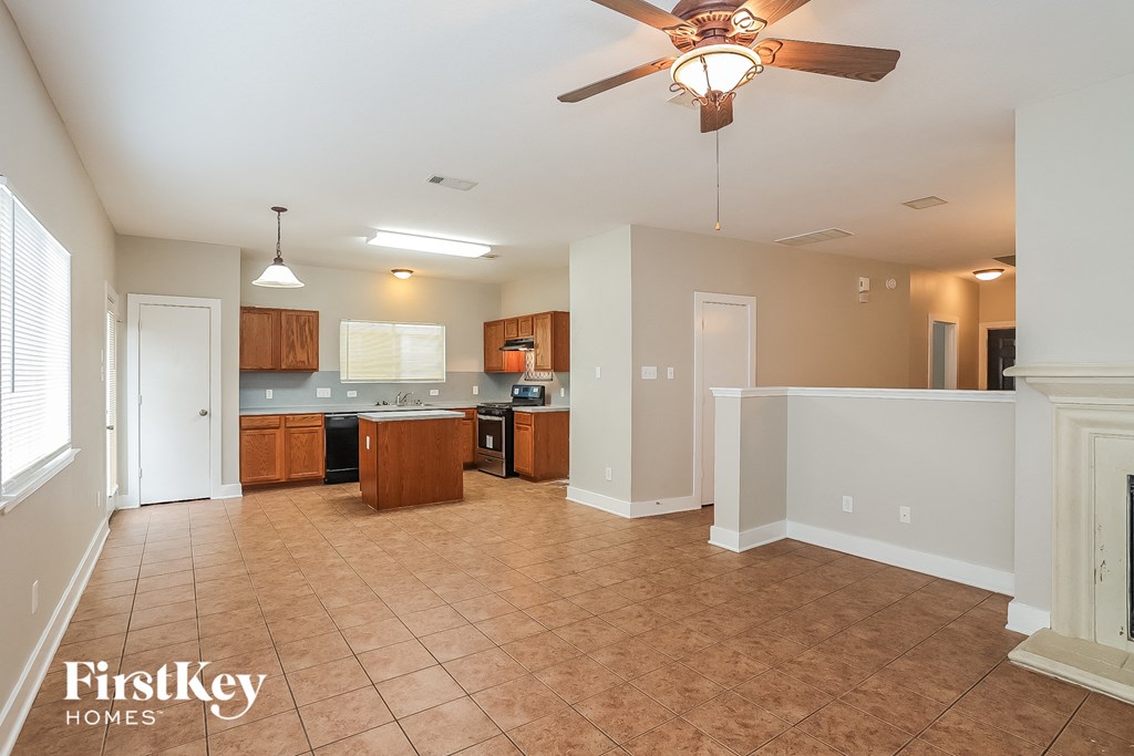 an empty kitchen and living room with a ceiling fan