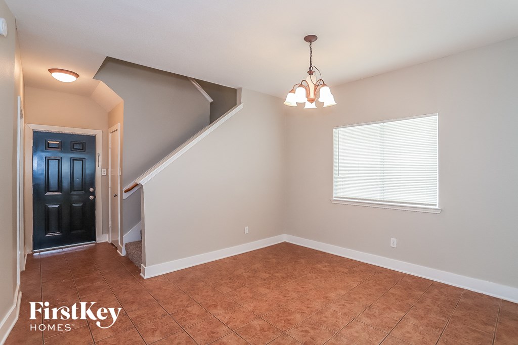 the living room of an attic with a staircase and a window