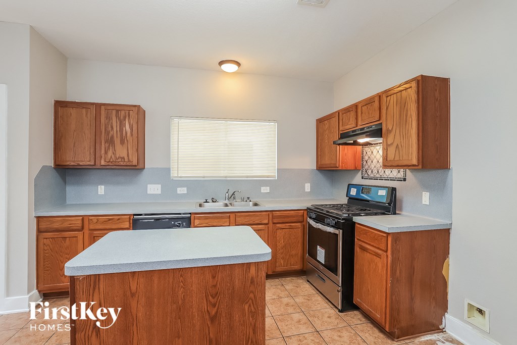 a kitchen with wooden cabinets and a stove and a sink