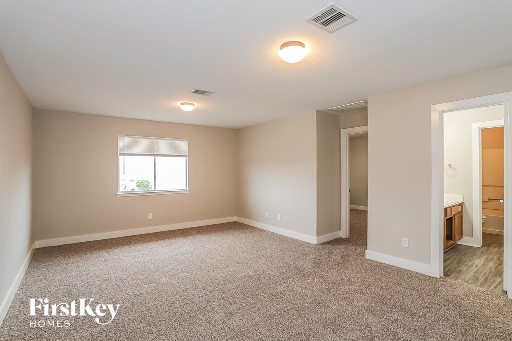 a spacious living room with carpeting and a window
