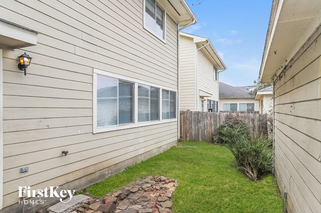the backyard of a house with a yard and a wooden fence