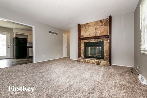 A room with a fireplace and a carpeted floor.
