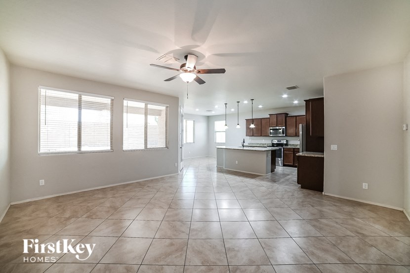 an empty kitchen and living room with a ceiling fan