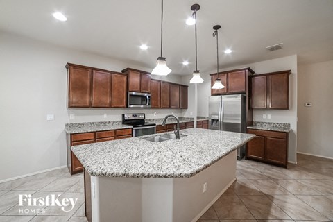 a kitchen with granite counter tops and wooden cabinets