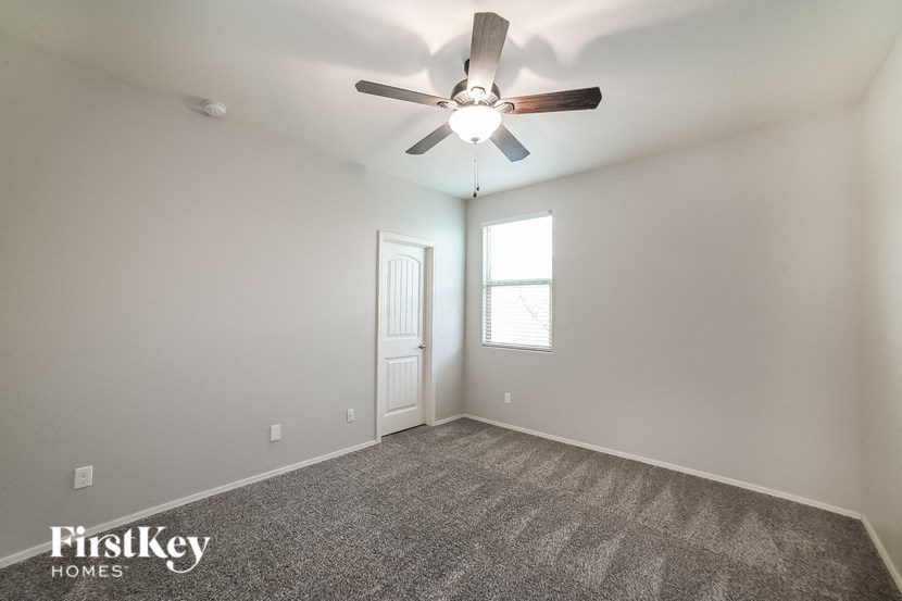 an empty room with a ceiling fan and a window