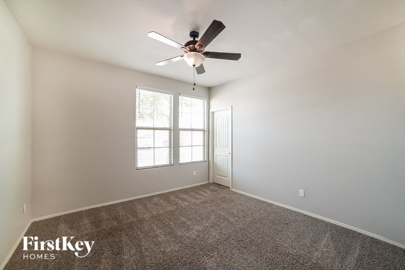 an empty room with a ceiling fan and a window