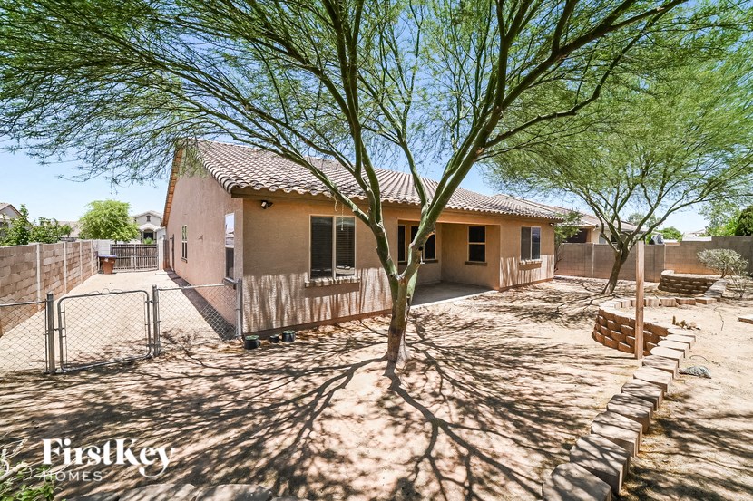 a house with a fence and a tree in the yard