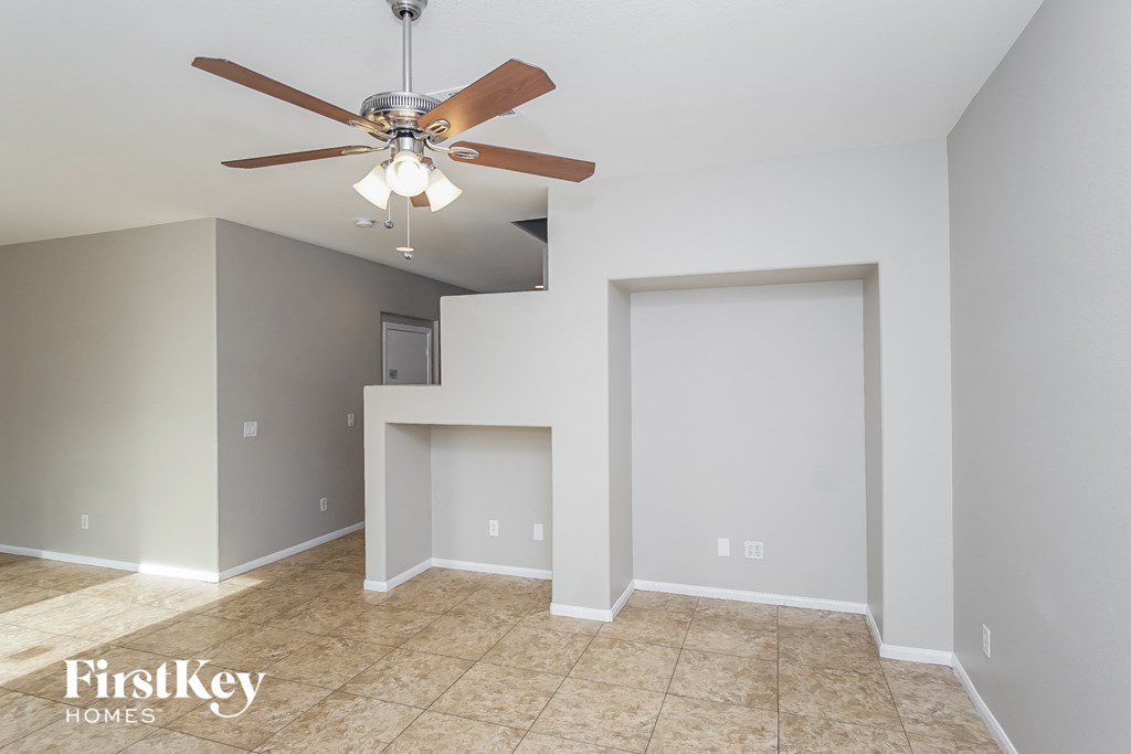 a living room with a ceiling fan and a door to a closet