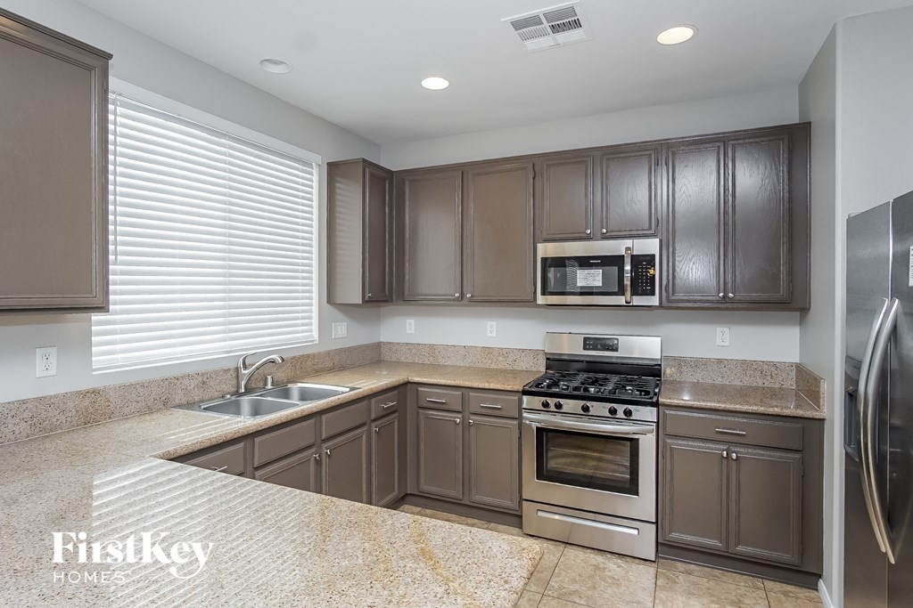 a kitchen with brown cabinets and stainless steel appliances