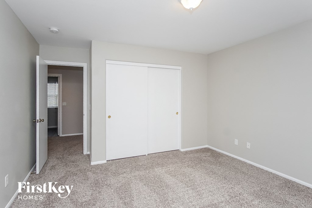 a bedroom with a closet and a door to a hallway