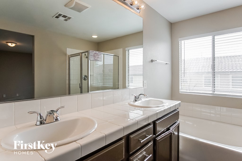 two sinks in a bathroom with a large mirror and a tub