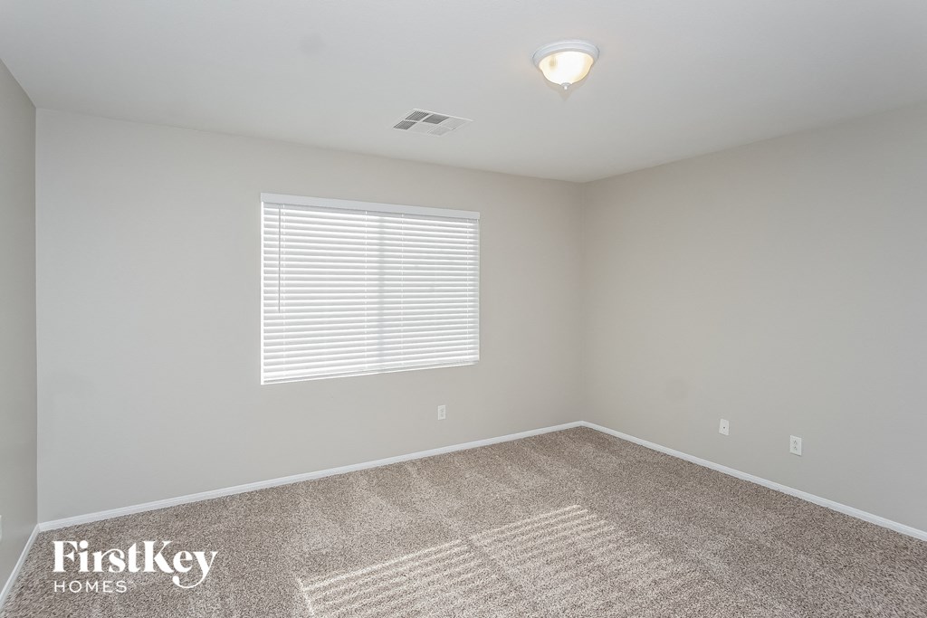 the living room of a new home with carpet and a window