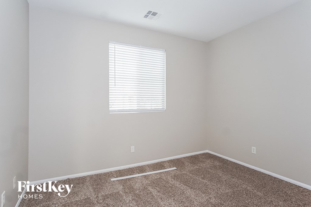 a empty room with carpet and a window