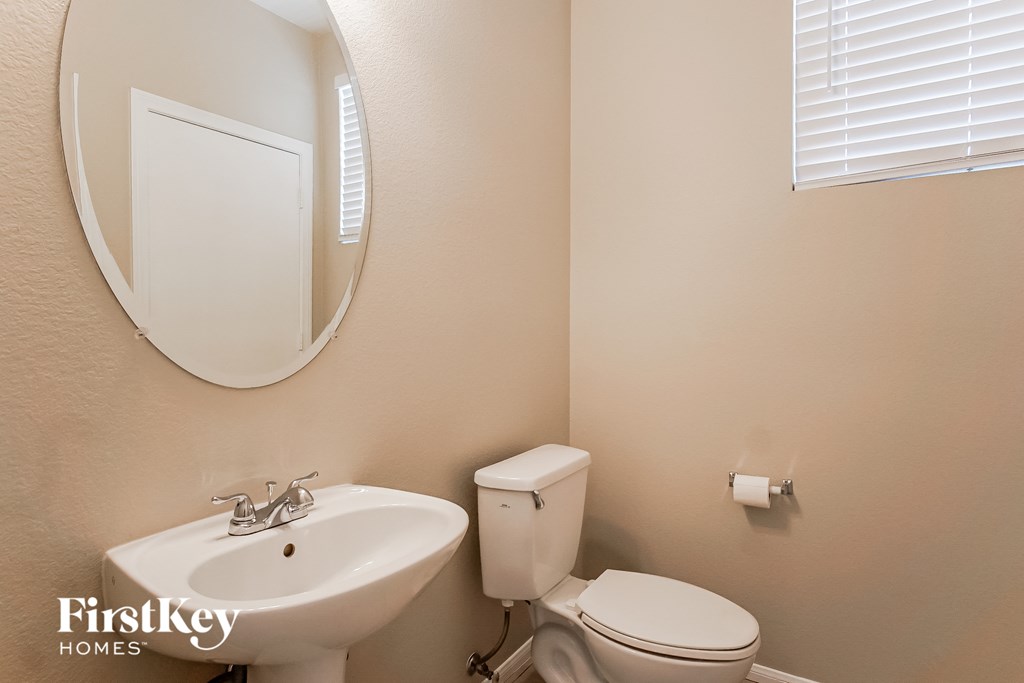 a bathroom with a sink toilet and a mirror