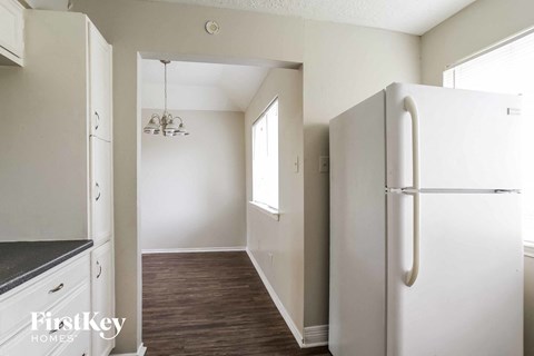a kitchen with white cabinets and a white refrigerator