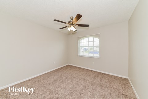 a bedroom with carpet and a ceiling fan