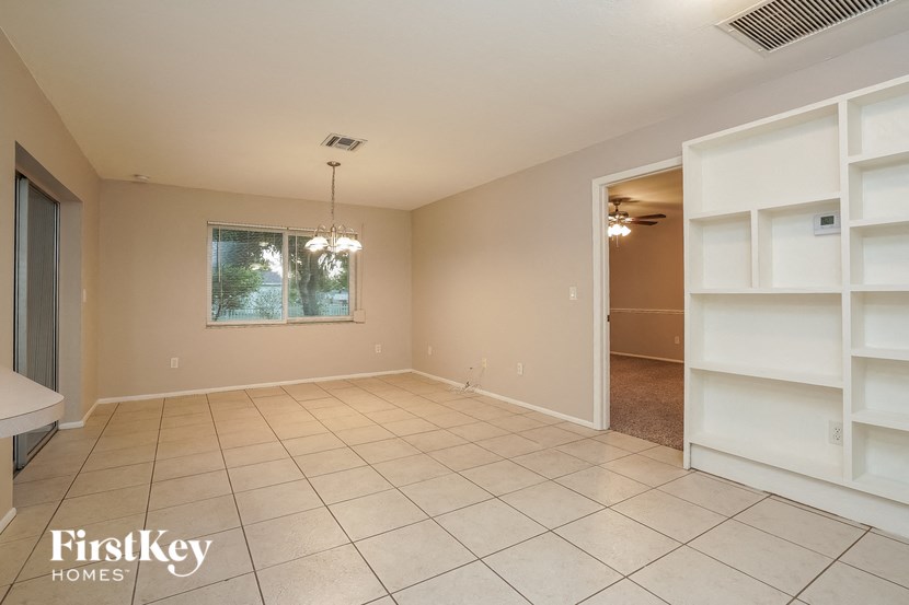 an empty living room with white shelves on the wall