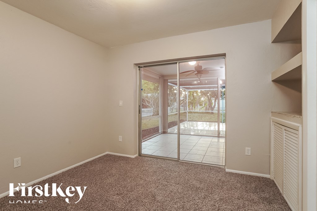 the living room of an empty house with a sliding glass door to the yard