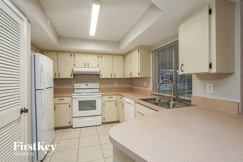 a large kitchen with white appliances and white cabinets