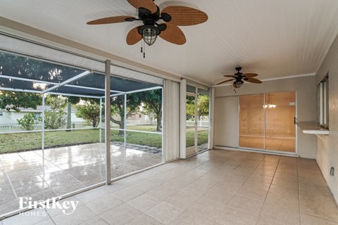 a living room with a ceiling fan and a sliding glass door