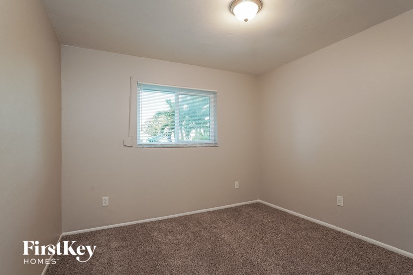 an empty room with a window and carpet