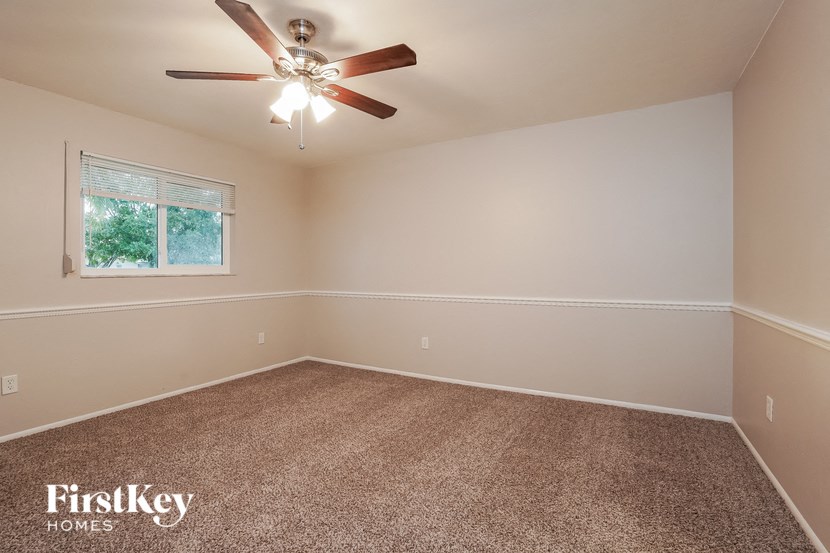 a empty room with a ceiling fan and a window