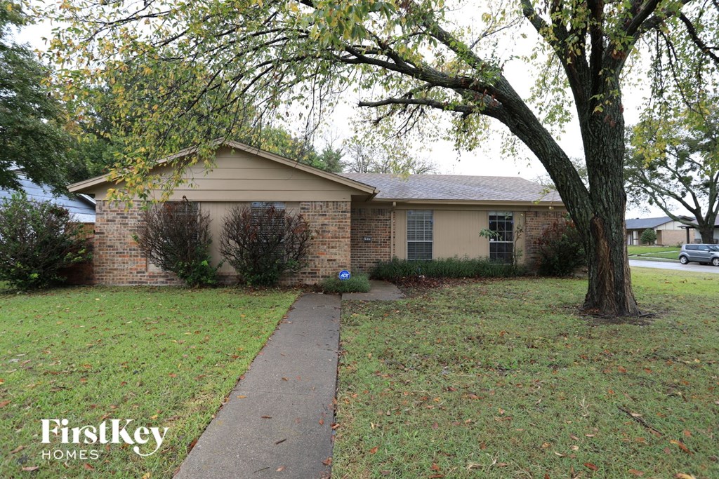 a small brick house with a tree in the yard