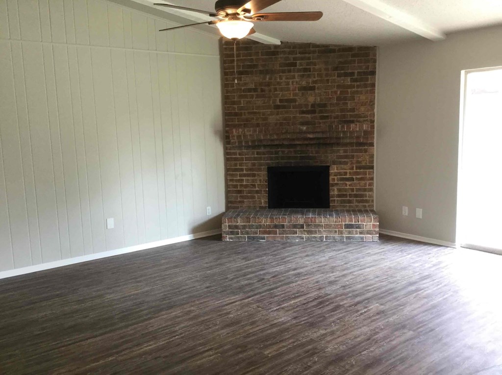 a living room with a fireplace and a ceiling fan
