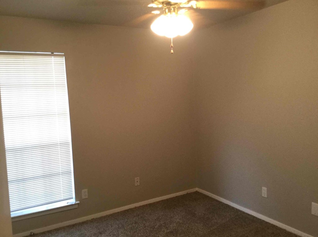 a bedroom with a ceiling fan and a window