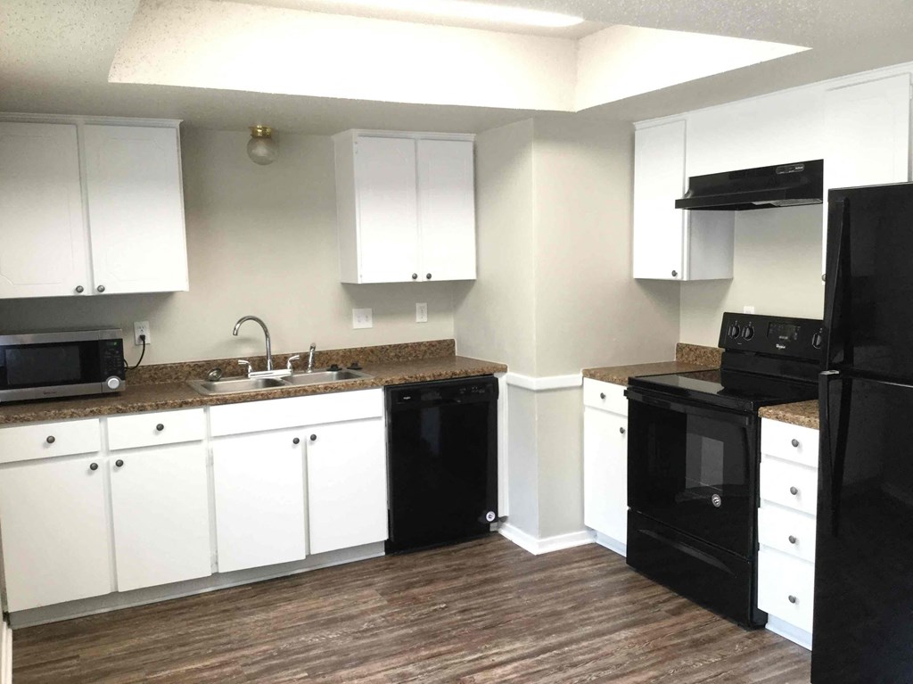 a kitchen with black appliances and white cabinets