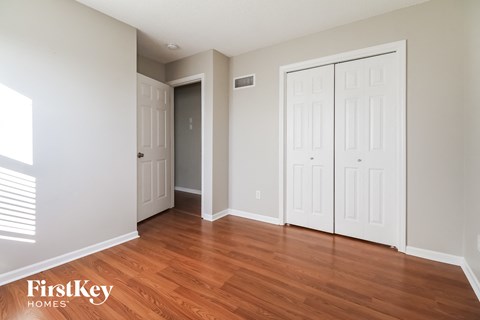 a bedroom with two closets and a hard wood floor