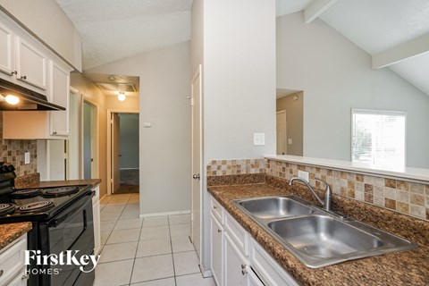 A kitchen with a stove top oven and a sink.