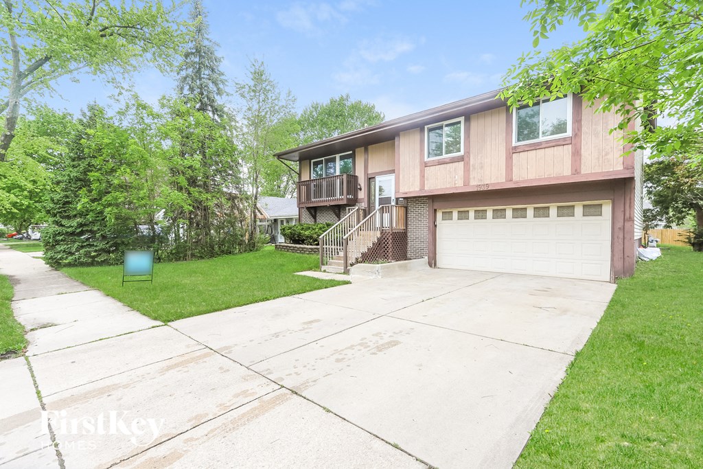A house with a garage and a driveway in front of it.