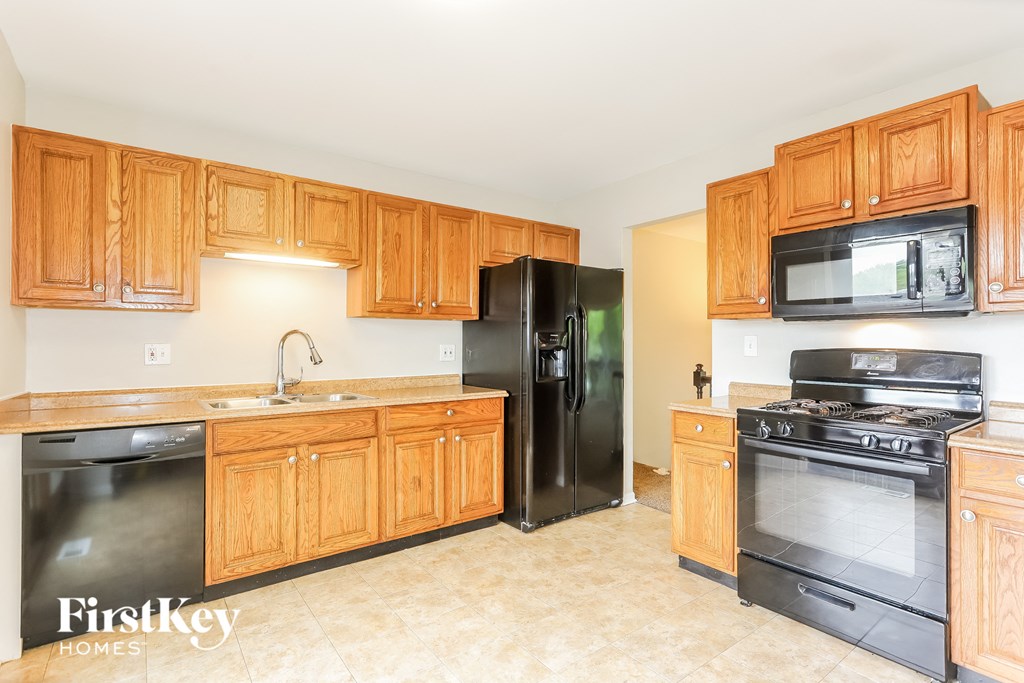 A kitchen with wooden cabinets and black appliances.