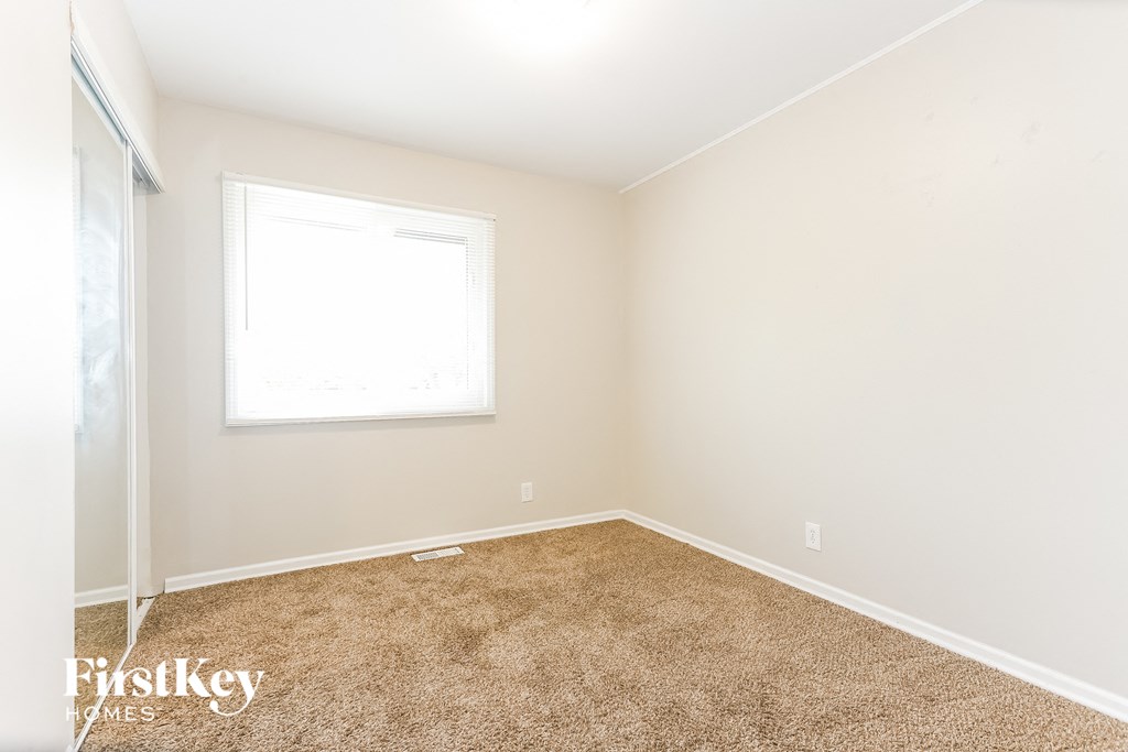 A room with a carpeted floor and a window.
