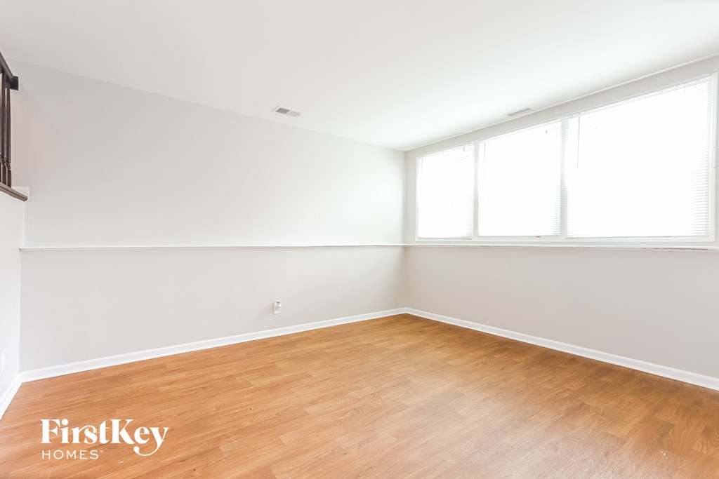 A room with wooden flooring and white walls.