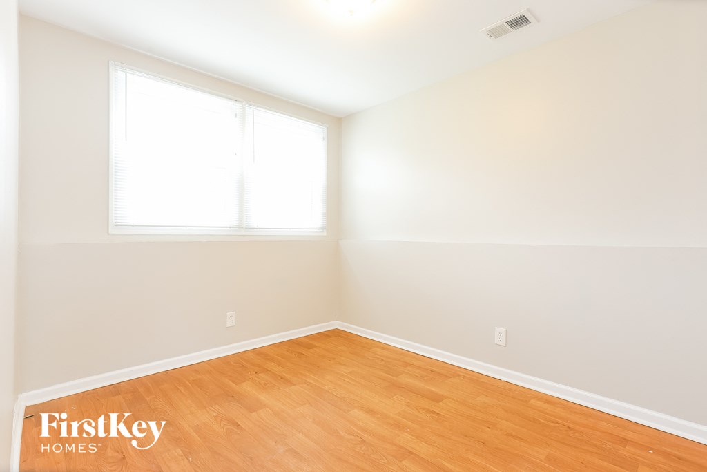 A room with wooden flooring and a window.