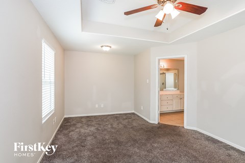 a living room with carpet and a ceiling fan